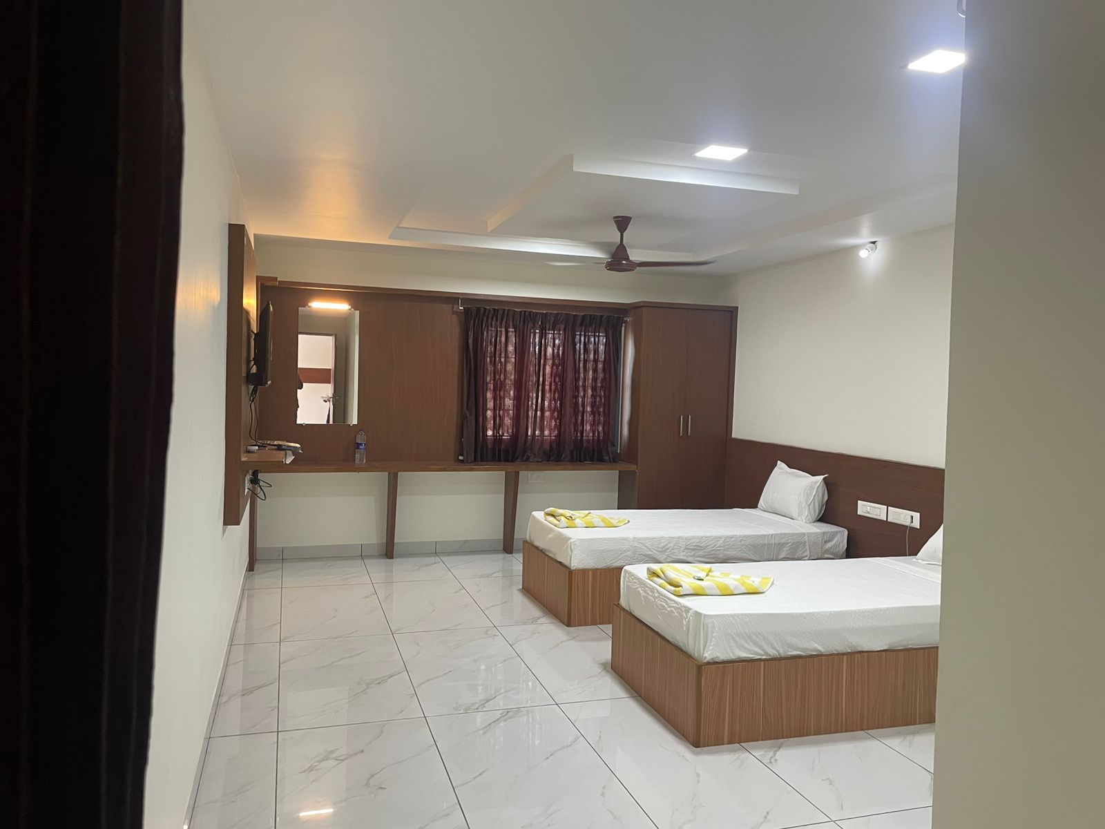 Well-lit hotel room with a comfortable queen bed and ample space for guests.